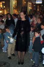 She is Spanish.  There is nothing else to say.  She is the epitome of a Spanish woman.  She is dripping her wax on the boy's wax ball.  At the end of Semana Santa the child with the largest wax ball gets a prize from the city.